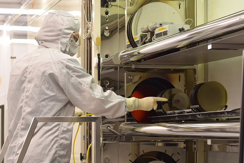 Lab worker in the Wolfspeed RF Foundry attending to wafers coming out of the oven.